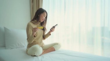 Evinden e-alışveriş yapan güzel Asyalı kadının görüntüleri.