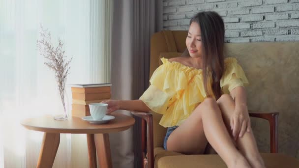 美しいアジア系女性が自宅でコーヒーを飲み — ストック動画
