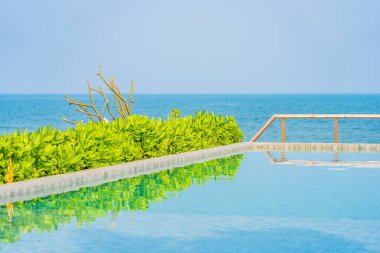 Dışarıda yüzme havuzu etrafında güzel boş bir sandalye şemsiyesi.