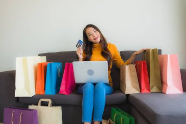 Genç Asyalı kadının akıllı mobili dizüstü bilgisayar kullanan portresi.