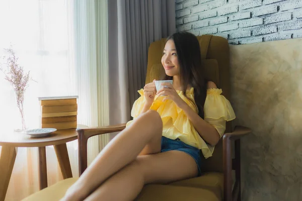 Retrato joven asiática mujer sentarse en sofá silla y leer libro con —  Fotos de Stock