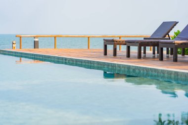 Dışarıda yüzme havuzu etrafında güzel boş bir sandalye şemsiyesi.