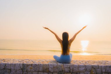 Genç Asyalı kadının portresi, deniz kıyısı okyanusunda meditasyon yapıyor. 
