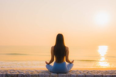 Genç Asyalı kadının portresi, deniz kıyısı okyanusunda meditasyon yapıyor. 