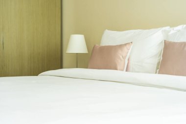 Yatak dekorasyonunda beyaz rahat yastık.