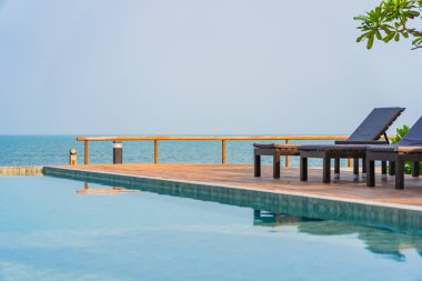 Dışarıda yüzme havuzu etrafında güzel boş bir sandalye şemsiyesi.