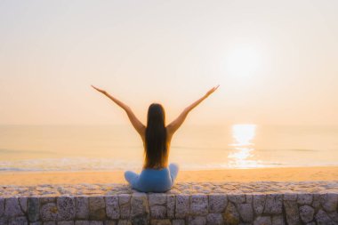 Genç Asyalı kadının portresi, deniz kıyısı okyanusunda meditasyon yapıyor. 