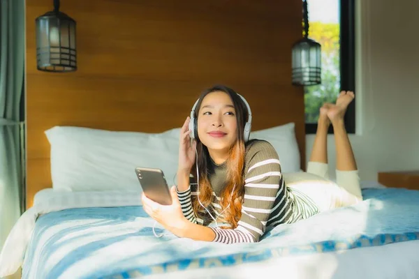 Портрет молодої азіатки, використовуючи смартфон з фонофоном — стокове фото