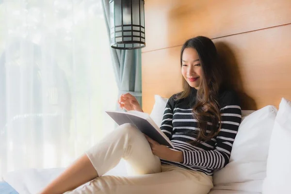 Ritratto giovane donna asiatica leggere libro in camera da letto — Foto Stock