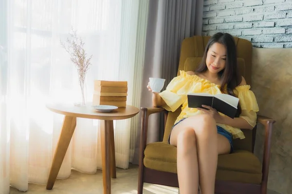 Retrato joven asiática mujer sentarse en sofá silla y leer libro con —  Fotos de Stock