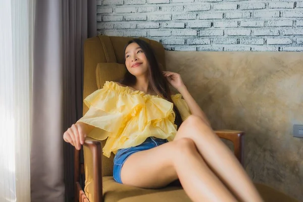 Portrét mladá asijská žena relax šťastný úsměv na pohovce židle v li — Stock fotografie