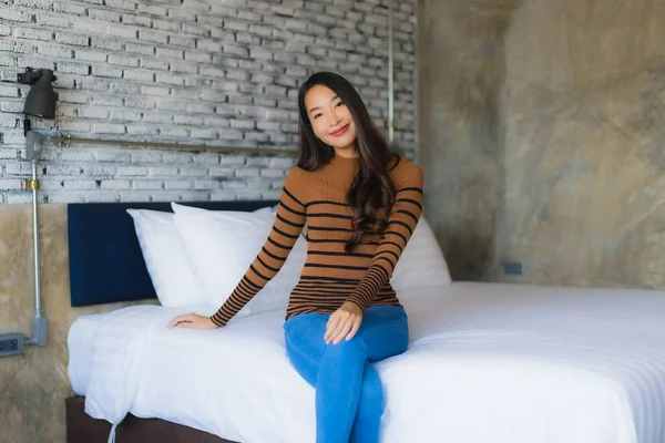 Fiatal ázsiai nő boldog mosoly pihenjen az ágyon a hálószobában — Stock Fotó