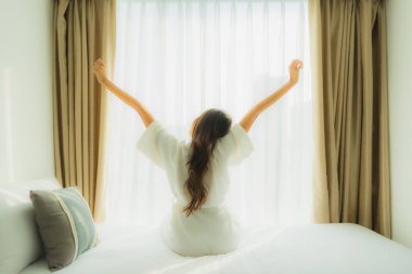 Genç Asyalı mutlu gülümseme. Yatak odasında rahatla.