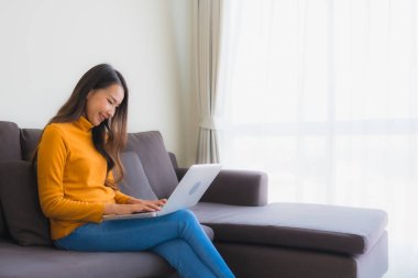 Dizüstü bilgisayarı kullanan Asyalı genç bir kadının portresi.