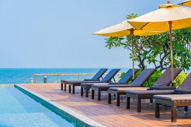 Dışarıda yüzme havuzu etrafında güzel boş bir sandalye şemsiyesi.