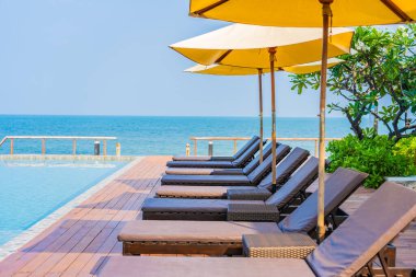 Dışarıda yüzme havuzu etrafında güzel boş bir sandalye şemsiyesi.