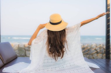 Asyalı genç bir kadının portresi. Mutlu bir gülümseme. Plajda rahatla.