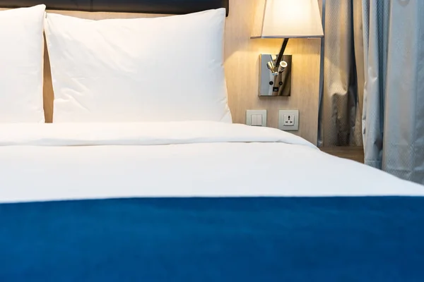 Белая удобная подушка и одеяло на постельном белье в спальне — стоковое фото