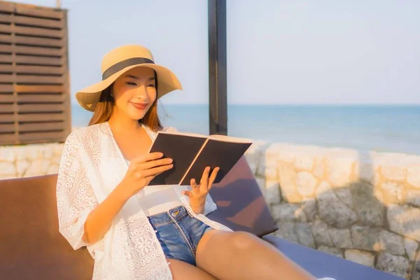 Portrait young asian woman read book around beach sea ocean
