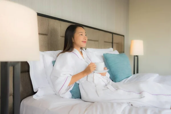 Porträt schöne junge asiatische Frauen mit Kaffeetasse auf dem Bett — Stockfoto