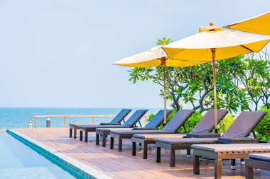 Dışarıda yüzme havuzu etrafında güzel boş bir sandalye şemsiyesi.