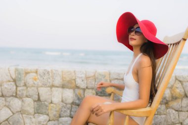 Asyalı genç bir kadının portresi. Mutlu bir gülümseme. Plajda rahatla.