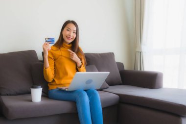 Genç Asyalı kadının akıllı mobili dizüstü bilgisayar kullanan portresi.