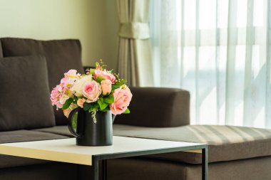 Yastık ve kanepe dekorasyonlu vazo çiçeği.