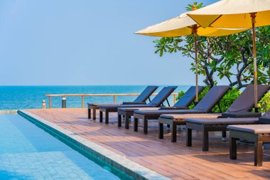 Dışarıda yüzme havuzu etrafında güzel boş bir sandalye şemsiyesi.