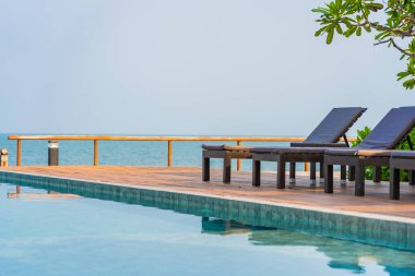 Dışarıda yüzme havuzu etrafında güzel boş bir sandalye şemsiyesi.