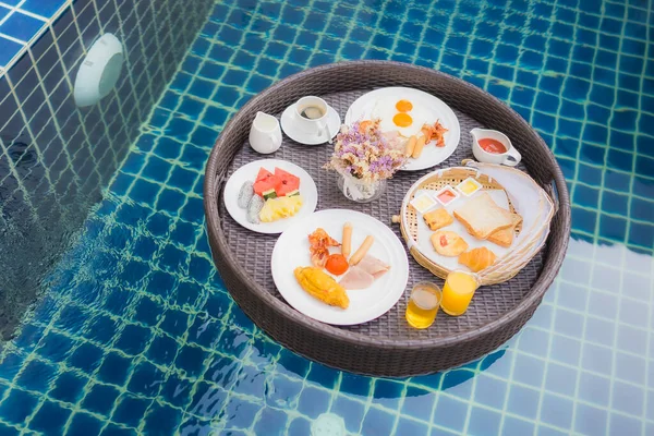 プールの周りに浮かぶ朝食セット — ストック写真