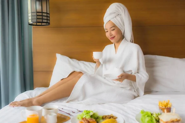 Портрет молодої азіатки на ліжку зі сніданком у спальні — стокове фото