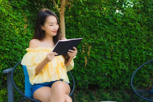 Giovane donna asiatica leggere libro intorno giardino all'aperto natura — Foto Stock