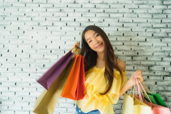 Porträtt ung asiatisk kvinna med färgglada shoppingväska — Stockfoto