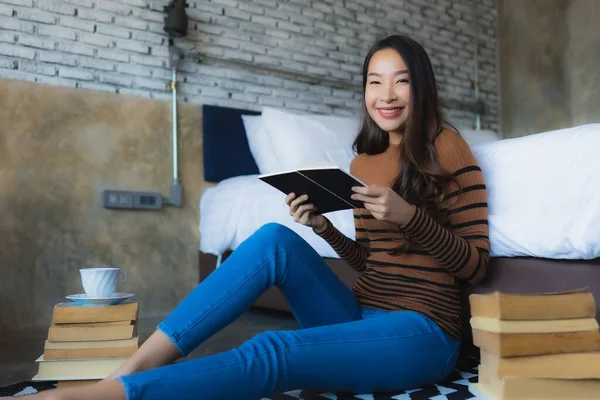 Joven mujer asiática con taza de café y leer libro — Foto de Stock