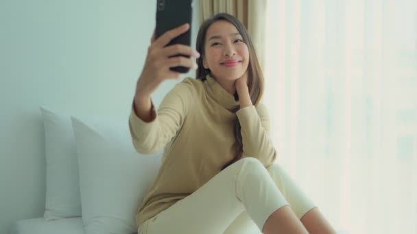 집에서 스마트폰을 사용하는 아름다운 이시아 여성의 — 비디오