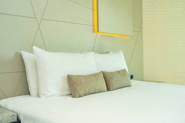 Yatak dekorasyonunda beyaz rahat yastık.