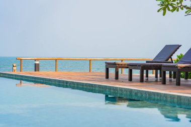 Dışarıda yüzme havuzu etrafında güzel boş bir sandalye şemsiyesi.