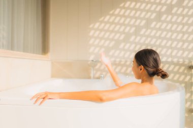 Portre genç Asyalı kadın rahatla küvette banyo yap.