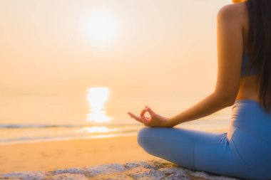 Genç Asyalı kadının portresi, deniz kıyısı okyanusunda meditasyon yapıyor. 