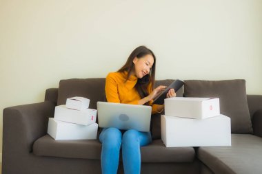 Genç Asyalı kadının portresi P ile çalışmak için dizüstü bilgisayar kullanıyor.