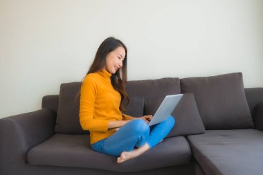 Dizüstü bilgisayarı kullanan Asyalı genç bir kadının portresi.