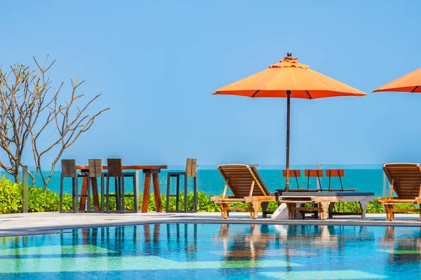 Ombrellone e sedia intorno alla piscina all'aperto neary mare in caldo — Foto Stock