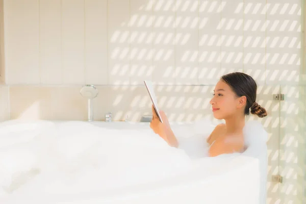 Retrato jovem mulher asiática usando telefone celular inteligente na banheira — Fotografia de Stock