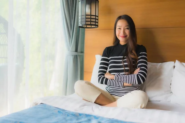 Portrait young asian woman happy relax smile on bed decoration i