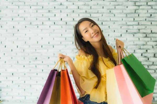 Porträtt ung asiatisk kvinna med färgglada shoppingväska — Stockfoto