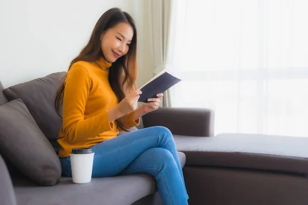 Ritratto giovane donna asiatica leggere libro su divano sedia con cuscino i — Foto Stock