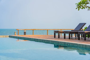 Dışarıda yüzme havuzu etrafında güzel boş bir sandalye şemsiyesi.