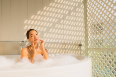 Portre genç Asyalı kadın rahatla küvette banyo yap.