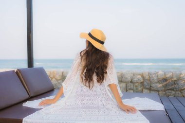 Asyalı genç bir kadının portresi. Mutlu bir gülümseme. Plajda rahatla.